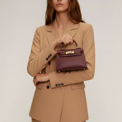 Diana S top-handle bag in hammered leather burgundy red — handheld view on model